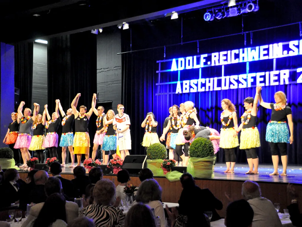 Tanzgruppe auf der blau beleuchteten Bühne.